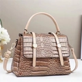 Detail van glanzend leer met krokodillenprint en gouden gespen op een vintage handtas - 24cmx11cmx17cm / Khaki