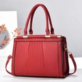 Detail of red lychee leather tote bag featuring pleated texture and gold hardware - Red