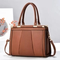 Borsa a mano marrone in pelle con texture a pieghe e hardware dorato su base bianca - Giallo Terra