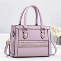 Detailaufnahme der lavendelfarbenen Handtasche mit Goldketten und Sechskant-Beschlägen - Lila