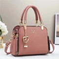 Elegant mauve faux leather tote bag with gold hardware and heart pendant on a white surface - Pink
