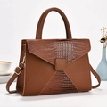 Brown leather crossbody bag with crocodile texture and adjustable strap in a stylish setup - Earthy Yellow