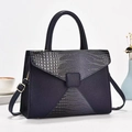 Detail of navy blue crossbody bag showing matte pebble and crocodile texture patchwork - Dark Blue