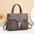 Close-up of gray tote bag featuring mixed crocodile and litchi grain leather textures - Gray