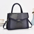 Detail of dark blue handbag featuring crocodile and lizard textured leather with gold hardware - Dark Blue