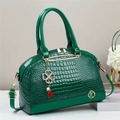 Dettaglio della borsa verde scuro effetto coccodrillo con ciondolo a quadrifoglio d'oro - Verde