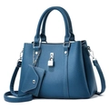 Détail macro du sac en cuir grainé avec cadenas en métal et mini porte-monnaie assorti - L29 L12 H21 / Bleu