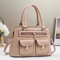 Detail view of pink lychee leather handbag featuring gold hardware and utility pockets - Pink