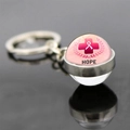 Macro shot of glass dome keychain with pink ribbon hope symbol and metal ring details - Hope (JY007298-11)
