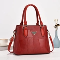 Dettaglio borsa a secchiello bordeaux con patchwork di pelle e logo in metallo - Rosso