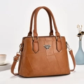 Detail of caramel brown bucket bag featuring geometric patchwork and gold metal hardware - Earthy Yellow