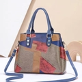 Nahaufnahme der mehrfarbigen Leder-Patchwork-Struktur und der Metallringe der Tasche - Rot