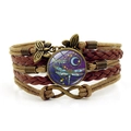 Primer plano de pulsera de cuero multicapa con domo de cristal de libélula y dijes - Marrón