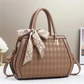 Close-up of mocha brown quilted leather tote bag with elegant silk scarf handle decoration - Khaki