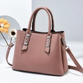 Detail view of pink leather handbag featuring a silver chain and detachable shoulder strap - Pink