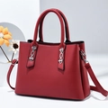 Detail of red PU leather handbag featuring silver chain buckle and adjustable strap - Red