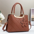 Detail of brown litchi grain PU leather bag with diamond stitching and flower charm - Earthy Yellow