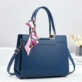 Detail of navy blue bucket bag with gold logo and decorative printed silk scarf on handle - L29cm W12cm H24cm / Blue
