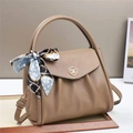 Detail view of coffee-colored lychee leather texture and golden metal M-logo on the handbag - L26 W14 H21 / Khaki