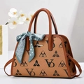 Detail of monogram leather tote bag with elegant silk scarf and gold metal hardware - Earthy Yellow