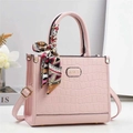 Dettaglio borsa a mano rosa con trama a coccodrillo e foulard decorativo in seta sul manico - Rosa