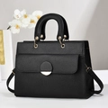 Close-up of black lychee grain leather handbag with gold clasp and shoulder strap - Black