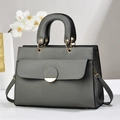 Detail of grey lychee texture handbag with gold hardware and trapezoid design - Gray