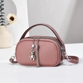 Pink multi-layer crossbody bag with bear charm and silver tassel in a lifestyle setting - 21x7x12cm / Pink
