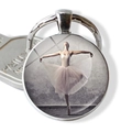 Macro shot of silver ballet dancer pendant keychain with vintage glass dome finish - White Dress Vintage Background (JY007576-5)