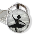 Detailed close-up of ballerina silhouette keychain with vintage musical score pattern - Black Silhouette Music Sheet Background (JY007576-6)