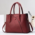 Burgundy woven texture tote bag with dual handles and gold hardware on white background - Wine Red