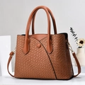 Close-up of brown tote bag featuring woven texture and gold metal buckle details - Earthy Yellow