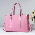 Pink bucket bag with lychee grain leather detail and golden hardware on grey background - Pink