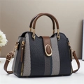 Bolso cubo de contraste con ribete de cuero marrón y detalles metálicos dorados - Negro