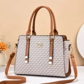 Nahaufnahme der bedruckten Handtasche in Creme mit goldenem Schloss und braunem Leder - Einheitsgröße / Erdgelb