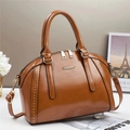 Elegant brown leather pillow handbag with metallic rivets and adjustable shoulder strap - Earthy Yellow