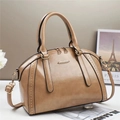 Khaki Boston pillow bag with golden studs and detachable strap in a minimalist setting - Khaki