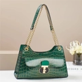 Detail of dark green crocodile texture handbag with gold metal lock and leather strap - Green