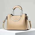 Close-up of beige lychee grain leather handbag featuring circular metal chain handles - Khaki