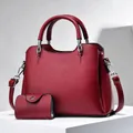 Detail view of burgundy pebble leather tote set with matching coin purse and silver hardware - Wine Red
