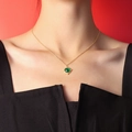 Vintage gold necklace with green agate pendant shown on model against red backdrop - Gold Agate