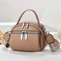 Detail of light brown lychee leather crossbody bag with dual silver zippers and patterned strap - Apricot