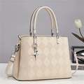Detail of quilted leather texture and silver cross star pendant on cream tote bag - Off White