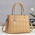 Close-up of quilted beige handbag featuring silver star pendant and premium leather texture - Yellow