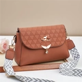 Detailed close-up of brown textured crossbody bag with wing buckle and geometric strap - Earthy Yellow