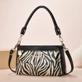 Dettaglio della borsa a tracolla nera zebrata con logo Danbaoly dorato e parti metalliche - 23*9*15cm / Strisce Zebra Nero Oro (Stile 3)