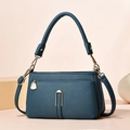 Macro detail of lychee pattern leather underarm bag with gold U-shaped metal hardware - Blue