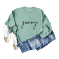 Detailed flat lay of a soft sage green sweatshirt featuring gammy heart print and denim shorts - Light Green (Black Text)