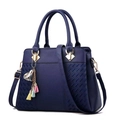 Dunkelblaue Lederhandtasche mit Flechtstruktur, goldener Hardware und buntem Quastenanhänger - Blau