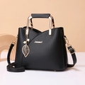 Elegante borsa in pelle nera con manico a U dorato e ciondolo decorativo con perla e foglia - Nero
